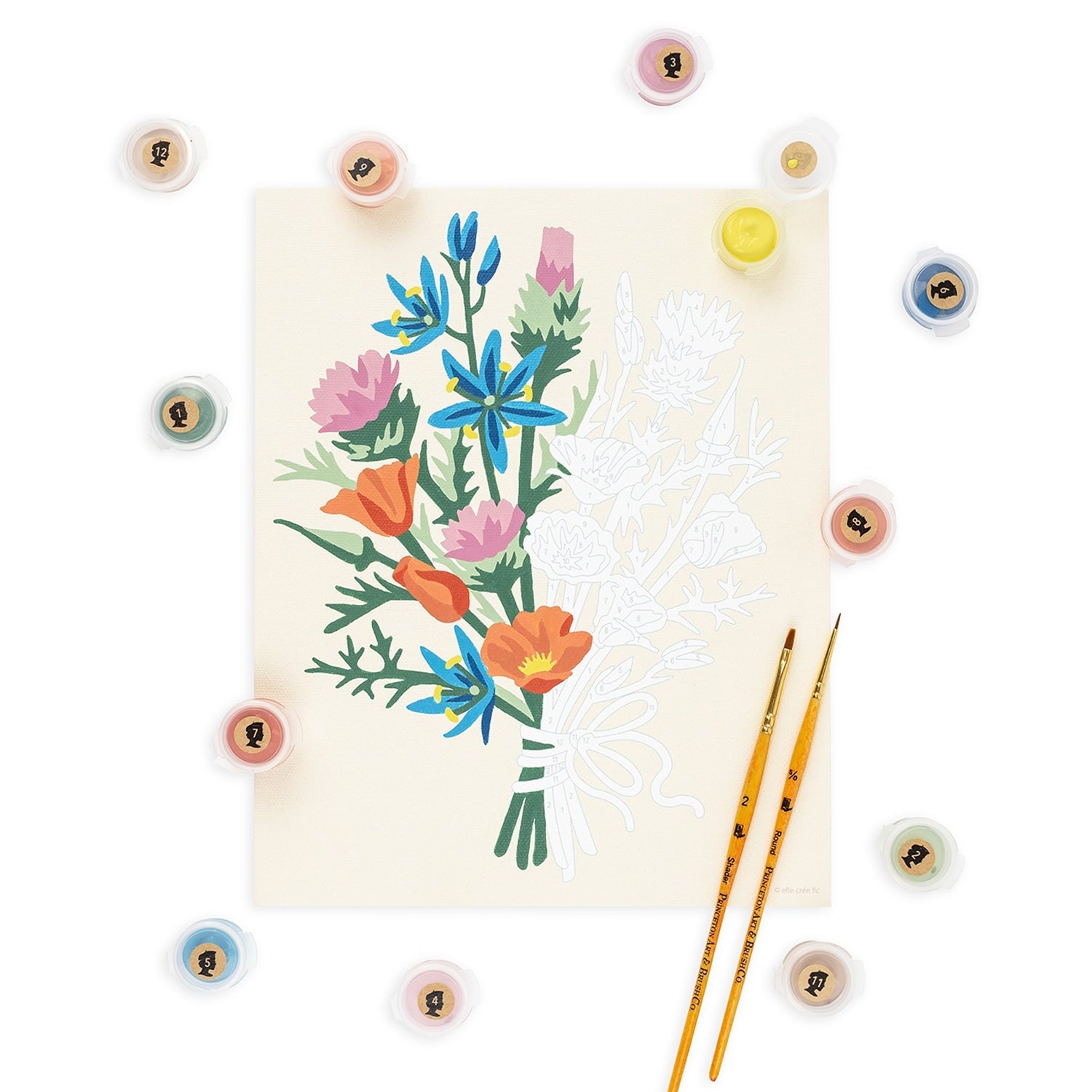 Floral illustration on a card with paintbrushes and paintstones around on a white background